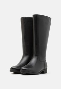 Knee-high black leather boots with a smooth finish, rounded toe, and minimal stitching. Sturdy low block heel and sleek, straight silhouette.