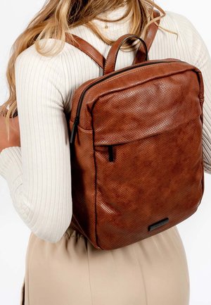 Hnědý kožený batoh s texturovaným povrchem, na zip, s nastavitelnými popruhy a přední kapsou. Kompaktní obdélníkový tvar.
