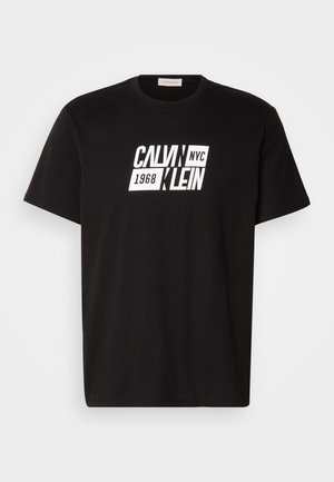 Sort bomulds T-shirt med korte ærmer, der har et iøjnefaldende hvidt grafisk print af "CALVIN NYC 1968 KLEIN" på forsiden. Klassisk rund halsudskæring.