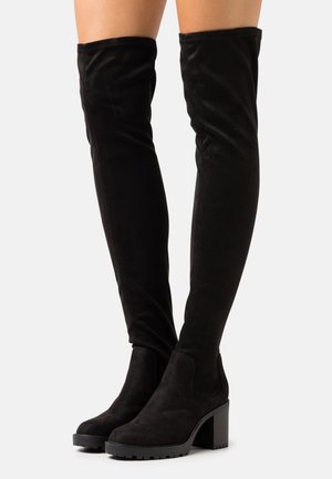Sorte ruskinds thigh-high støvler med en kraftig blokhælhæl og elastisk top. Sålen har et mønster for bedre greb.
