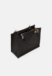Schwarze Leder-Tote mit goldfarbenen Beschlägen, mit zwei Griffen und einem erhabenen Markenlogo. Strukturierte Form mit offenem Oberteil und Reißverschlusstaschen.