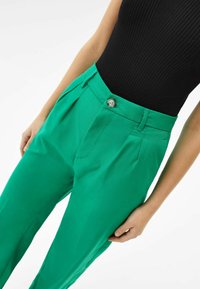 Gröna byxor med skräddarsydd passform, veck framtill, knappstängning och ett mjukt, lätt tyg.