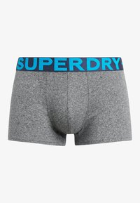 Bermudas de algodón gris con una cinturilla azul marino y el logotipo "SUPERDRY" en azul claro, textura suave y diseño que se ajusta al cuerpo.