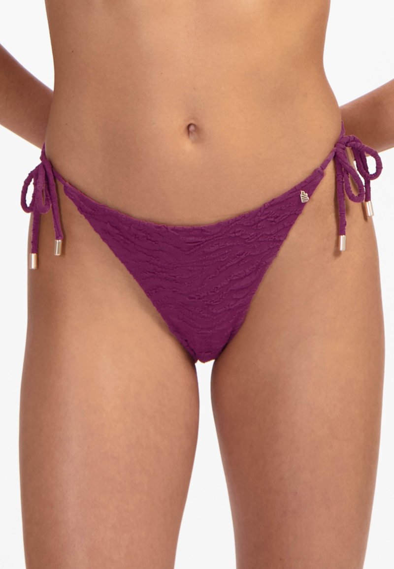 Lila Spitzen-Bikinislip mit strukturiertem Muster, seitlichen Bindungen und Metallakzenten. Verfügt über einen tiefsitzenden Schnitt für minimale Bedeckung.