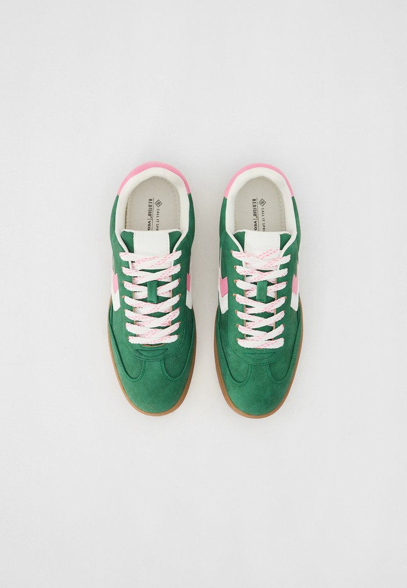 Baskets en suede vert avec des accents blancs et des détails roses. Équipées de lacets roses et d'une semelle en caoutchouc gomme. Design sportif classique.