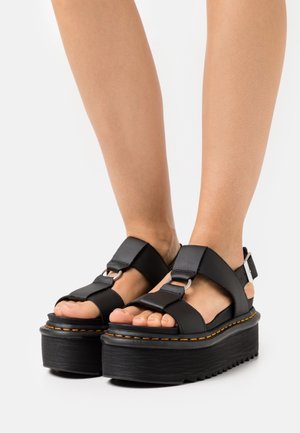 Schwarze Plattform-Sandalen mit dicken, strukturierten Sohlen. Verfügen über breite Riemen mit silberner Hardware und einem verstellbaren Knöchelriemen.