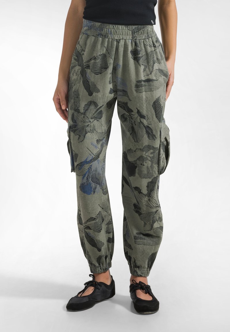 Pantalones cargo en verde oliva con un patrón floral en azul oscuro y negro. Presentan una cintura elástica y puños ajustados en los tobillos.