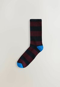 Gestreepte sok met bordeauxrode en zwarte verticale strepen, een ribbelstructuur en een blauwe teen en hiel. Katoenmix materiaal voor comfort.
