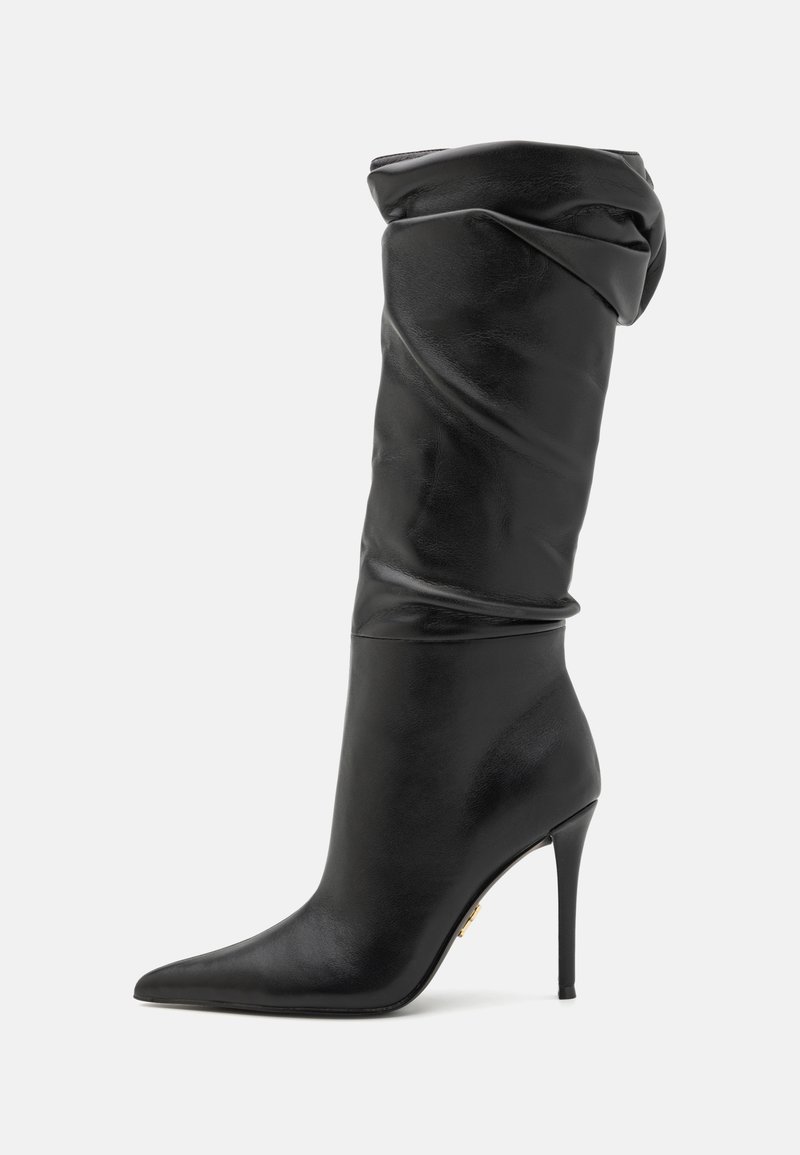 Stivale in pelle nera al ginocchio con parte superiore morbida, punta affusolata e tacco a stiletto sottile. Texture liscia con minimi dettagli in metallo.