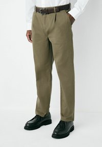 Olive green trousers with a straight-cut design, featuring belt loops and a brown leather belt. Paired with black lace-up shoes.