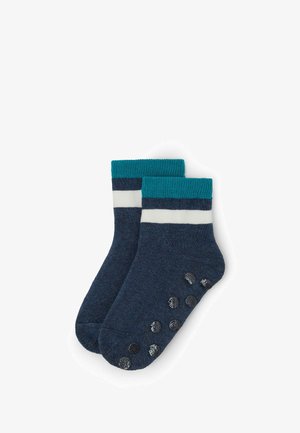 Blå sokker med en teal ribbet manchet, hvide og mørkeblå striber. Har gummigrebsdutter på sålen for bedre trækkraft.