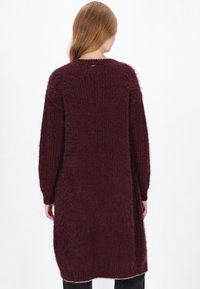 Burgundowa, długosleeve'owa sweterka dziewiarskiego z teksturalnym, puszystym wykończeniem i bocznymi rozcięciami, z okrągłym dekoltem i średniej długości krojem.