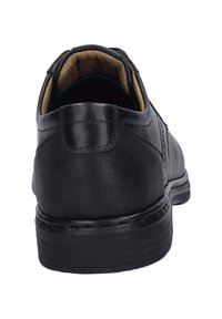 Scarpa di cuoio nera, con superficie strutturata, tacco rotondo e interno imbottito. Presenta un design classico e cuciture visibili.