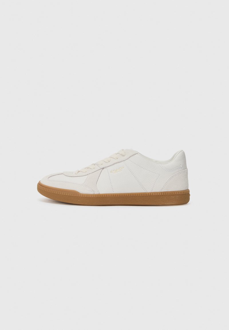 Hvite sneakers med en teksturert lærøverdel og gummisåle. Kjennetegn inkluderer snøring og subtil merkevaredetaljering på siden.
