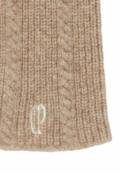 Bufanda de punto beige hecha de lana, con una textura acanalada y un pequeño logotipo blanco. El diseño incluye patrones diagonales y verticales.