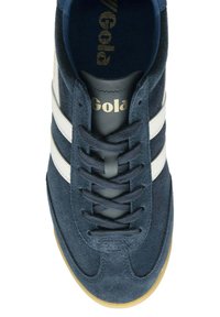 Marinblå mockasneakers med vita läderstrimmor, rund tå, platt snörning framtill och sula av gummigummi. Guld "Gola"-logotyp på tungan.