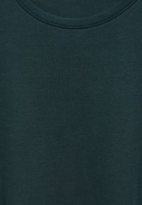 Tummanvihreä puuvillapaita, jossa on pyöreä pääntie. Paidan pinta on sileä ja kaula-aukossa on hillitty ompelusyksityiskohta.