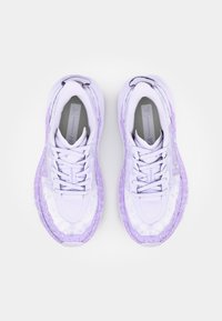 Le scarpe da corsa viola presentano una tomaia in rete, sovrapposizioni testurizzate e una suola imbottita. I lacci sono piatti, con il marchio visibile sul lato.