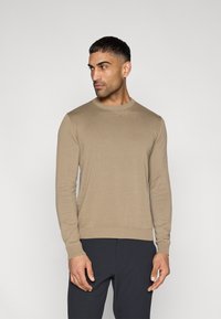 Μπεζ πλεκτό πουλόβερ με στρογγυλή λαιμόκοψη, μακριά μανίκια και ριμπ μανσέτες και τελείωμα. Ομαλή υφή και εφαρμοστή γραμμή.