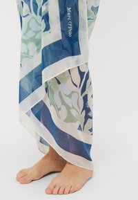 Bufanda ligera con estampado botánico en tonos azules, verdes y cremosos, con un borde en contraste y la marca "Marc O'Polo".