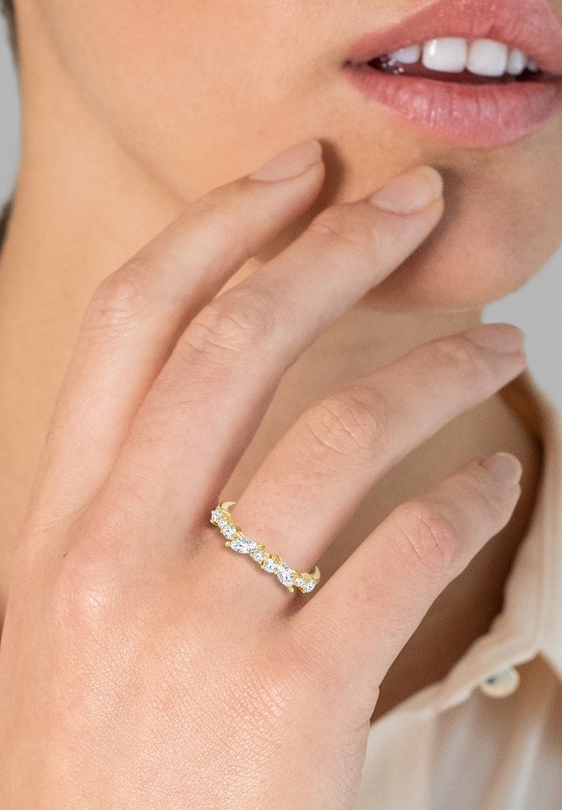 Guldring med fem klara, marquise-slipade stenar som är satta i en elegant klo-design. Slät ring och polerad yta kompletterar stenarna.