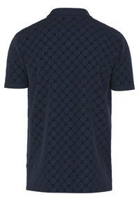 Polo shirt bleu marine avec un motif texturé de formes superposées, manches courtes et col classique. Tissu doux avec des accents de couture détaillés.