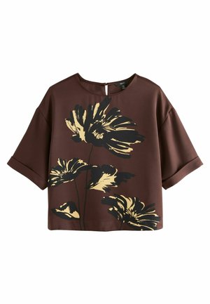 Braunes Kurzarmshirt mit floralen Motiven, das große gelbe und schwarze Blumenmuster zeigt, einen runden Ausschnitt hat und über eine Schlüsselöffnung auf der Rückseite verfügt.