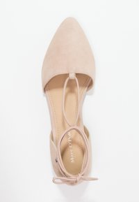 Scarpa piatta in suede beige con punta appuntita e laccetto alla caviglia. Presenta una texture liscia e una fodera interna a contrasto con il logo del marchio.