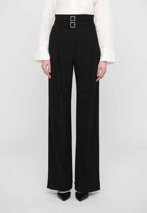 Black high-waisted trousers with a double-belted design, wide legs, and a structured fabric. Features creases and folded hems.