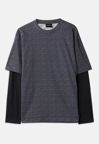 Rövid ujjú ing geometrikus kék és fekete mintával. Jellemzője egy fekete hosszú ujjú réteg alatta, kerek nyak és puha textúra.