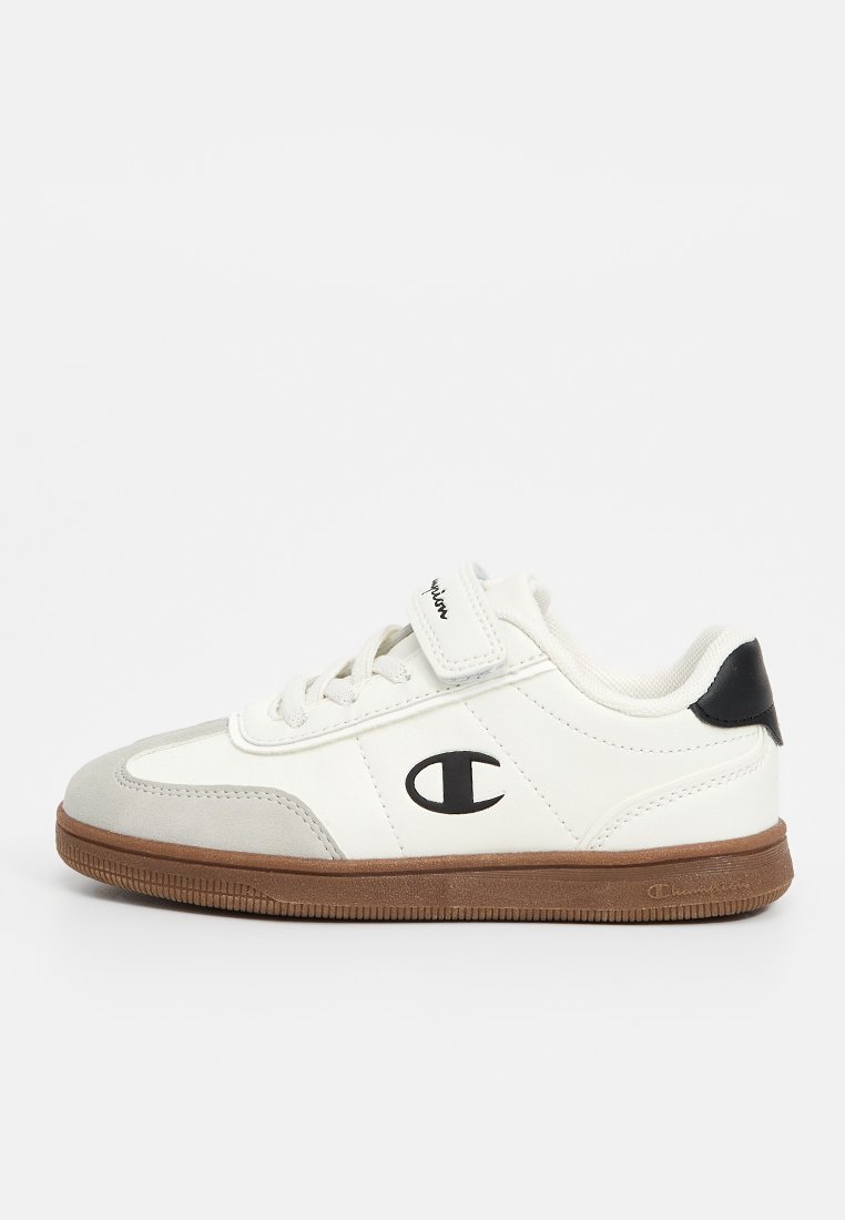 Zapatillas blancas con detalles en gamuza gris y un talón negro. Cuentan con una correa frontal y cordones tradicionales. Suela de goma con agarre texturizado.