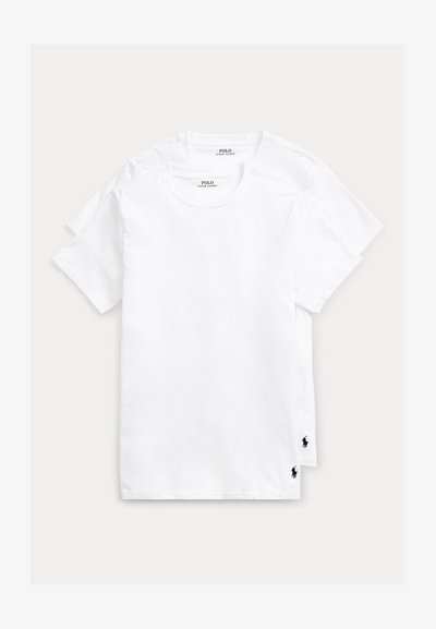 Duas t-shirts brancas de algodão com gola redonda. Cada uma apresenta um pequeno logótipo preto de polo no lado inferior esquerdo. Textura suave, corte padrão.