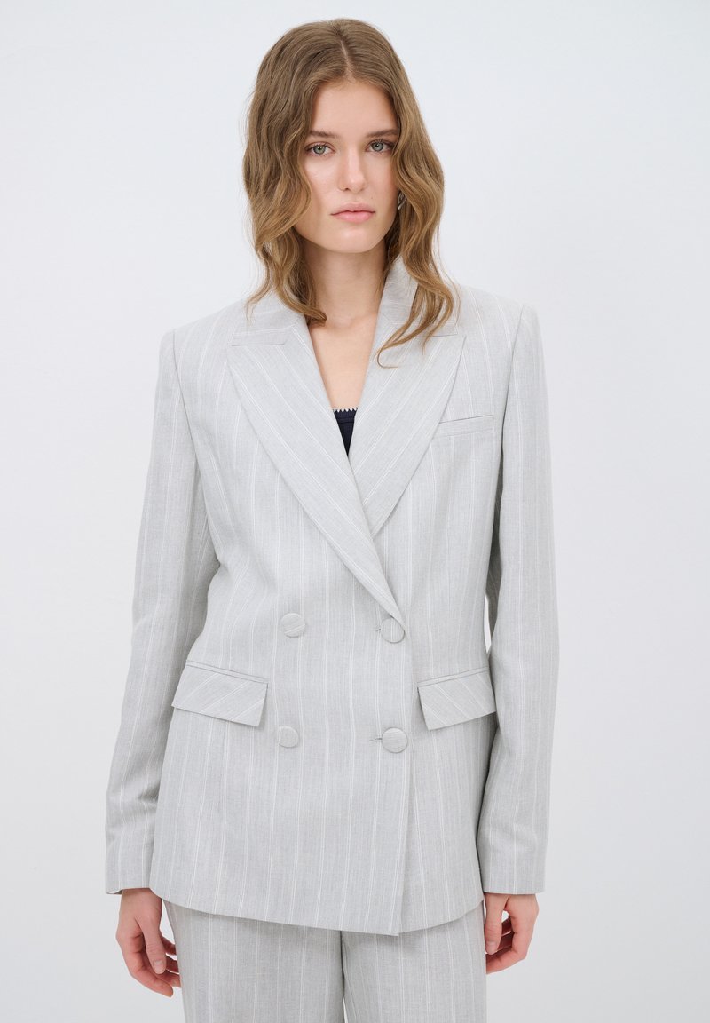 Lichtgrijze double-breasted blazer met subtiele verticale strepen, ingeknikte revers, twee voorkruiszakken en ronde knopen. Gestructureerde stof.