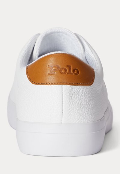 Witte leren sneaker gezien vanaf de achterkant met een bruine leren patch gegraveerd met "Polo" op de hielkraag.