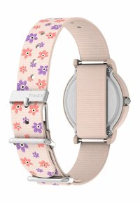 Timex pulksteņa josta ar tekstūru, gaiši rozā krāsā, ar ziedu rakstiem purpursarkanā un koraljkrāsā, sudraba detaļām un apaļu korpusu.