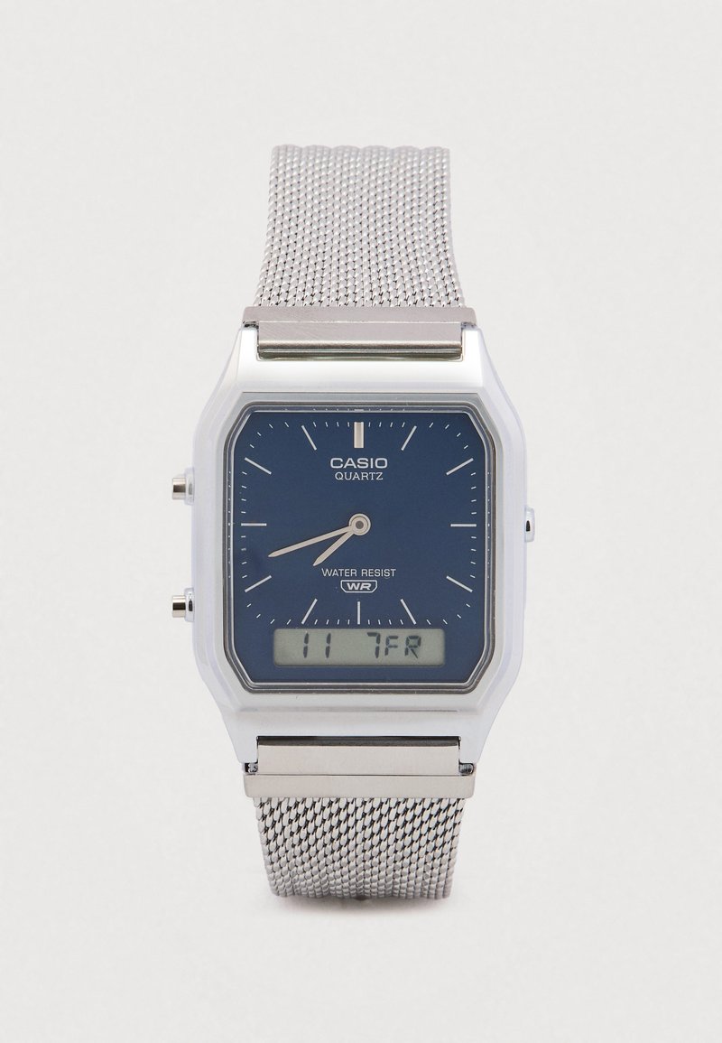 Orologio Casio al quarzo con quadrante blu, cinturino a maglia d'argento, cassa quadrata in plastica, display digitale e funzione di resistenza all'acqua.