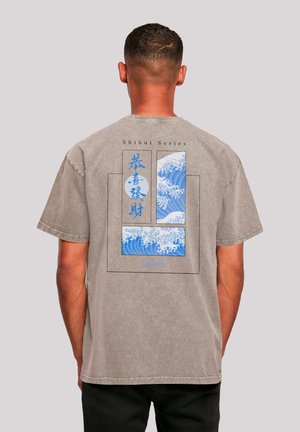 Gray short-sleeve t-shirt featuring a blue wave graphic on the back, with text "Shibui Series" above and a box design framing the artwork.