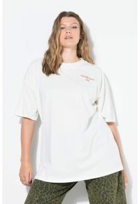 Camiseta blanca de gran tamaño con mangas cortas, que presenta el texto rojo "sunday picnic club" en el lado izquierdo. Material de algodón suave.
