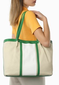 Borsa a tracolla in tela con rifiniture in pelle verde. Presenta una striscia centrale bianca e due manici verdi, realizzata in una forma strutturata con una finitura testurizzata.