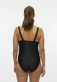 Maillot de bain une pièce noir avec bretelles réglables, tissu doux et couverture modérée au dos, présentant une texture lisse et un design sans coutures.