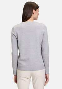 Hellgrauer Pulli aus weichem Material, mit langen Ärmeln, Rundhalsausschnitt und geripptem Saum und Bündchen. Keine sichtbaren Muster.