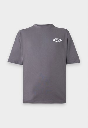 T-shirt gris à manches courtes col rond avec un petit logo blanc circulaire représentant une silhouette stylisée sur le côté gauche de la poitrine.