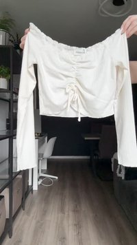 Witte, off-the-shoulder cropped top, met een gathered voorkant met trekkoord, lange mouwen, ribbelstructuur en een losse pasvorm.