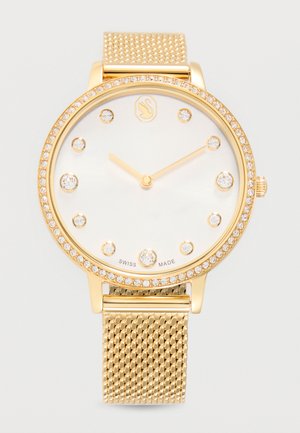 Guldfarvet armbåndsur med diamantmarkeringer, hvid urskive, mesh-rem og krans pyntet med små krystaller, viser tiden 10:09.