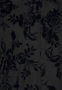 Tessuto nero con un delicato motivo floreale in rilievo, con rose nere e foglie, creando un effetto strutturato su uno sfondo scuro.