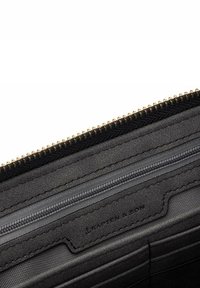 Zwart leren portemonnee met rits, interieur van textuurleer, met een grijze rits en kaartslots. "Kapten & Son" debossed label zichtbaar.