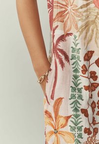 Lina rõivas lillemustritega, punaste, oranžide ja roheliste kujundustega; küljetasku; kaasas hõbedast kett käevõru.