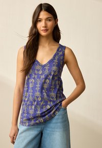 Canottiera viola con scollo a V, caratterizzata da un motivo astratto dorato. Realizzata in tessuto morbido, si abbina bene a jeans blu casual.