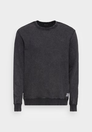 Sweatshirt noir à col rond avec manches longues, poignets et ourlet côtelés. Texture douce avec un petit logo brodé sur le bas.