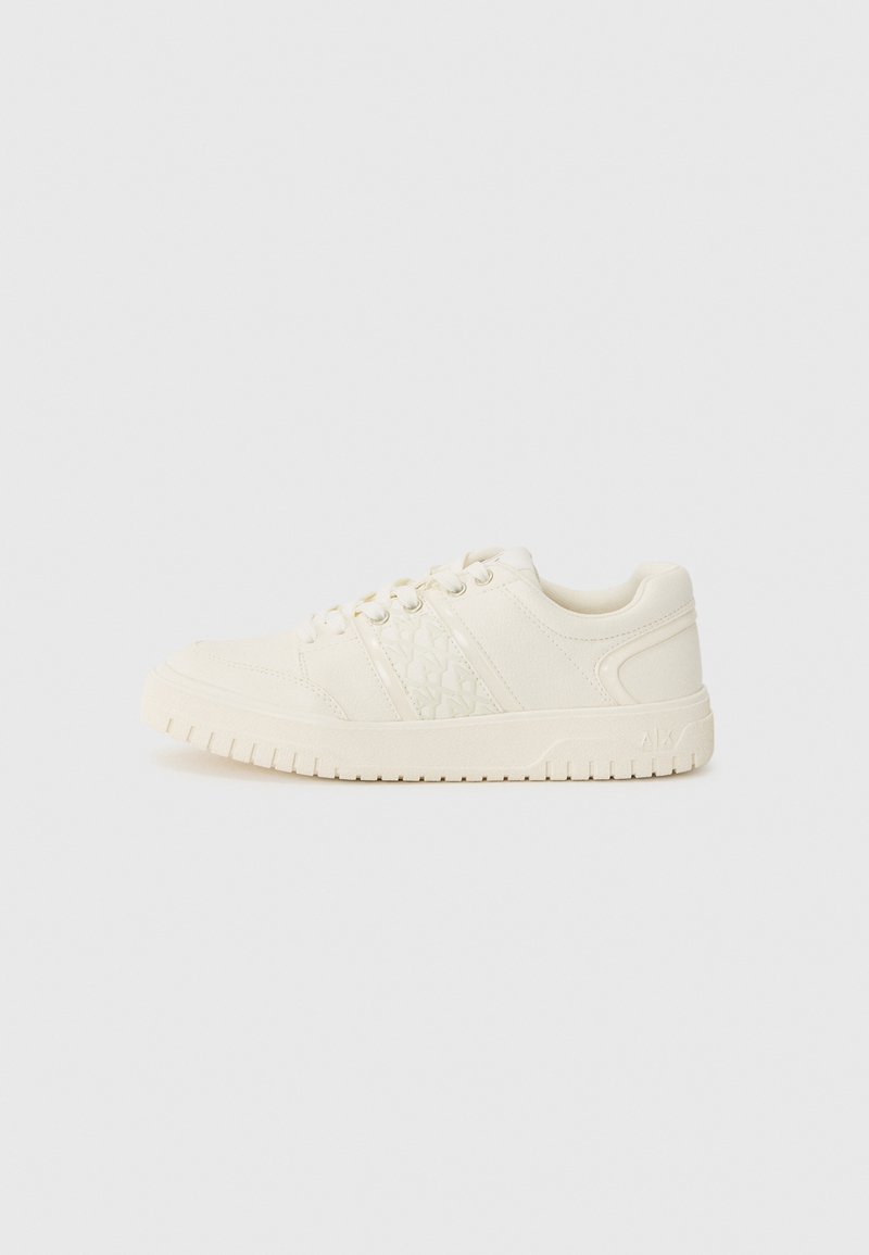 Baskets blanches avec une finition texturée, dotées de trois rayures latérales, de lacets ronds et d'une semelle épaisse et striée. Design minimaliste.